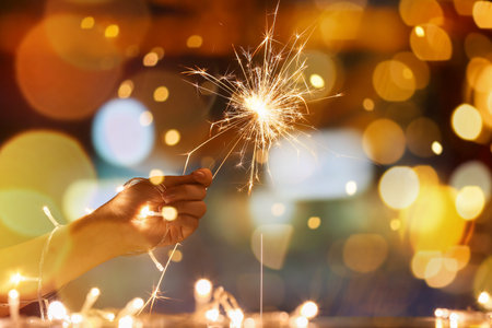 Woman with Christmas sparkler at night, closeupの写真素材