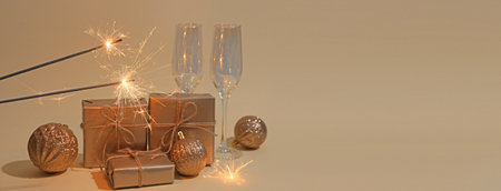 Christmas sparklers, balls and gift boxes on beige background with space for textの写真素材
