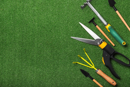 Gardening tools on green grass background