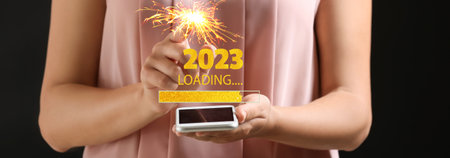 Woman with mobile phone on dark background. Concept of New Year 2022