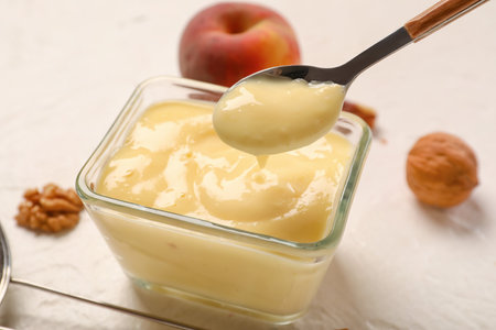 Glass bowl of delicious vanilla pudding on light background, closeupの写真素材