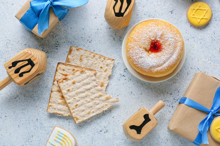 Composition wooden dreidels, gift boxes and delicious food for Hanukkah celebration on light...