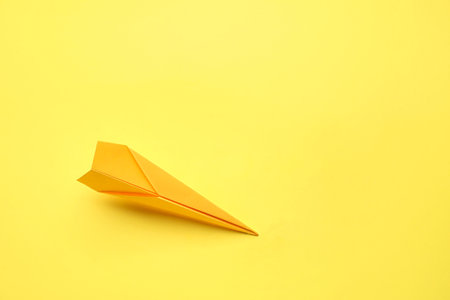 yellow paper plane on color backgroundの写真素材
