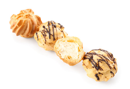 Tasty round eclairs with cream on white background