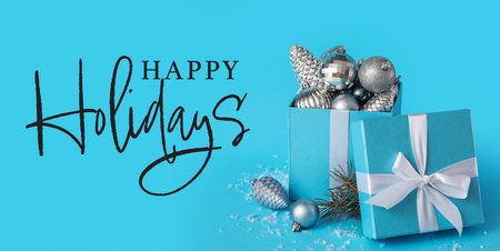 Gift box with Christmas decor and text HAPPY HOLIDAYS on blue backgroundの写真素材