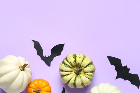 Halloween pumpkins and paper bats on lilac backgroundの写真素材