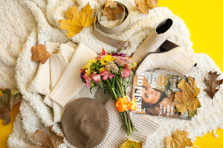 Elegant female accessories, soft plaid, bouquet of flowers and autumn leaves on yellow background