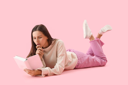 Beautiful woman reading book on pink background