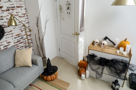 Interior of modern living room with sofa, chest of drawers and Halloween decorの写真素材