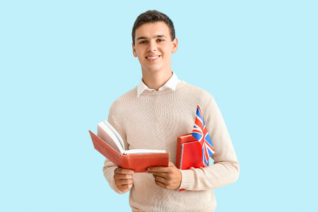 Teenage boy with UK flag and book on blue backgroundの写真素材