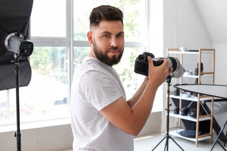 Male photographer with professional camera working in studioの写真素材
