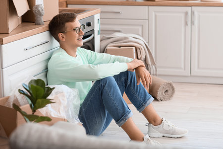 Young man sitting in the kitchen on moving dayの写真素材
