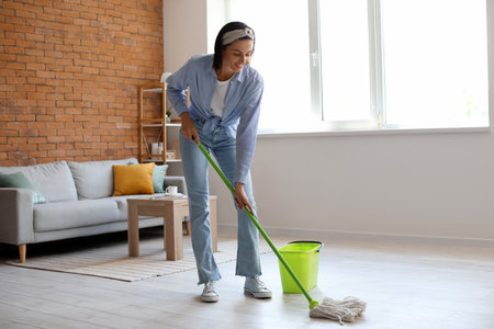 Young housewife mopping floor at homeの写真素材