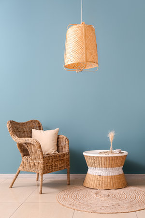 Rattan armchair and table near blue wallの写真素材