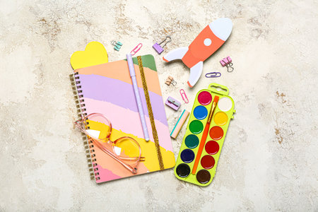 Paper rocket with school stationery and eyeglasses on grunge backgroundの写真素材