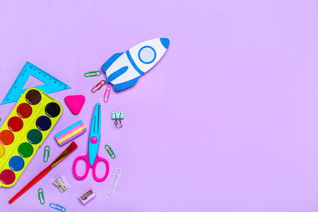 Paper rocket with school stationery on violet backgroundの写真素材