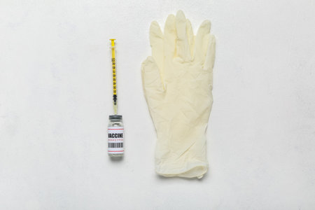 Monkeypox vaccine with syringe and gloves on white background