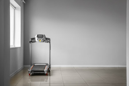 Modern treadmill near light wall in roomの写真素材
