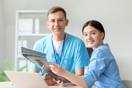 Medical assistants studying x-ray scan in clinic