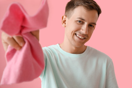 Young man with rag on pink background