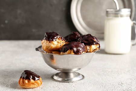 Bowl with delicious eclairs on tableの写真素材