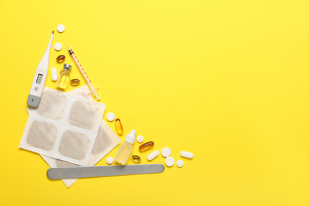 Mustard plasters with medicines and thermometer on yellow backgroundの写真素材