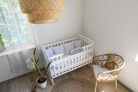 Baby crib, armchair and toys in light nurseryの写真素材