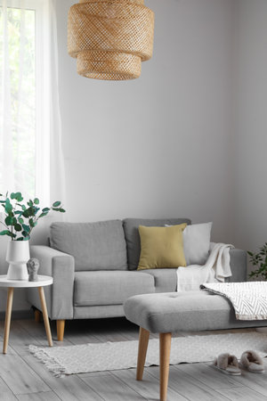 Interior of light living room with soft bench, sofa and houseplantsの写真素材