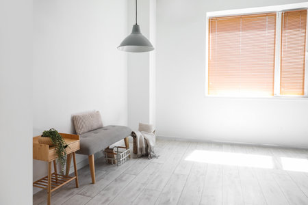 Soft bench with baskets and table near light wallの写真素材