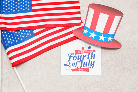 Greeting card for Independence Day, USA flags and paper hat on light backgroundの写真素材