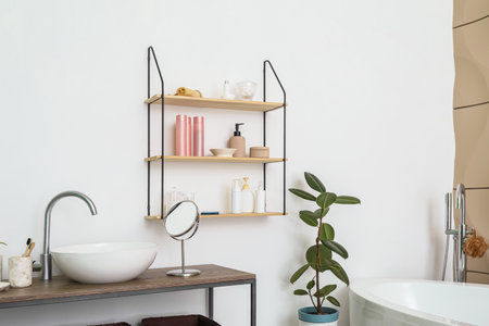 Modern sink and bath accessories on table near white wallの写真素材
