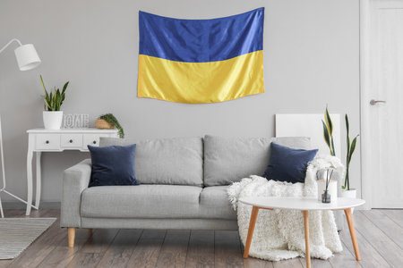 Interior of light living room with hanging Ukrainian flag, sofa and houseplantsの写真素材