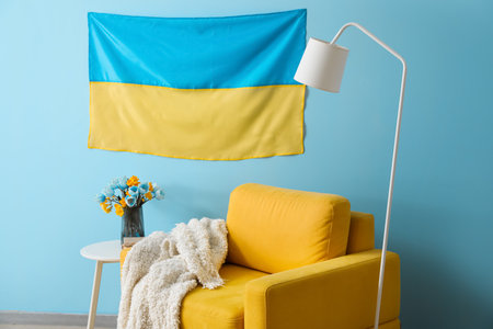 Interior of stylish living room with hanging Ukrainian flag, armchair and tableの写真素材
