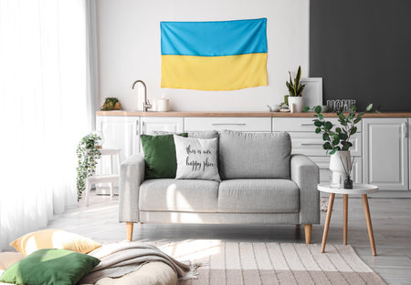 Interior of light kitchen with hanging Ukrainian flag, counters and sofaの写真素材