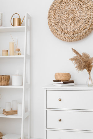 Chest of drawers and shelving unit with decor near light wallの写真素材