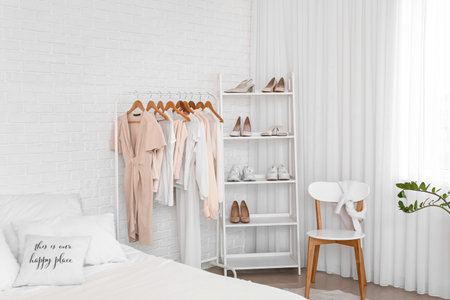 Interior of light bedroom with stylish clothes and shoesの写真素材