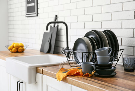 Modern black dinnerware on counter near white brick wall