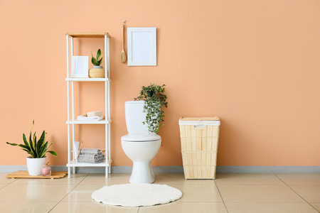 Interior of restroom with toilet bowl, shelving unit and laundry basketの写真素材