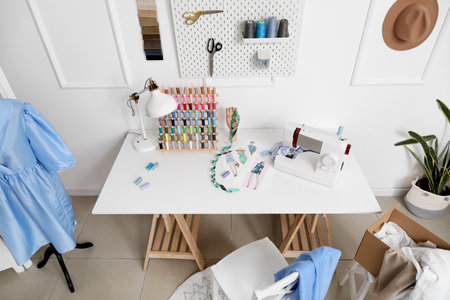 Modern tailor's workplace with sewing machine and thread spools in atelierの写真素材