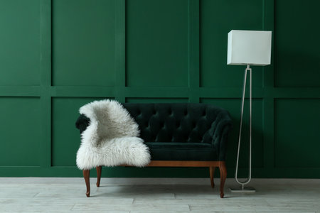 Stylish sofa and lamp near green wallの写真素材