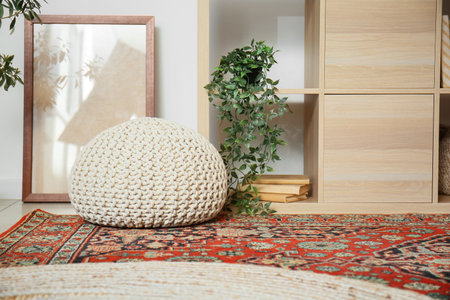 Stylish pouf on vintage carpet in living roomの写真素材