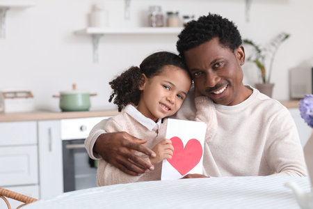 Little African-American girl greeting her dad on Father's Day in the kitchenの写真素材