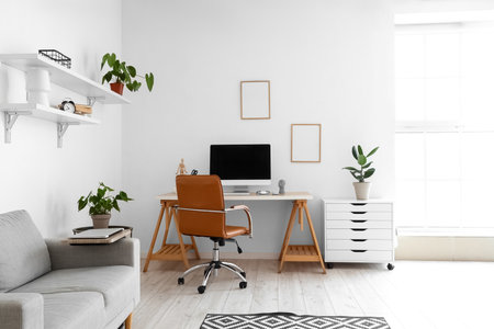 Light interior of room with comfortable workplace and modern computerの写真素材