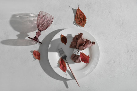 Beautiful autumn table setting with fallen leaves on white background