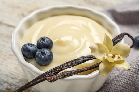 Ramekin of delicious vanilla pudding on table, closeup
