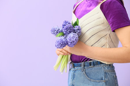 Pretty young woman with hyacinth flowers on color backgroundの写真素材