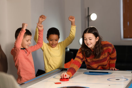 Little children playing air hockey indoorsの写真素材
