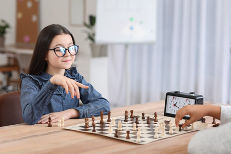 Little girl playing chess during tournament in clubの写真素材