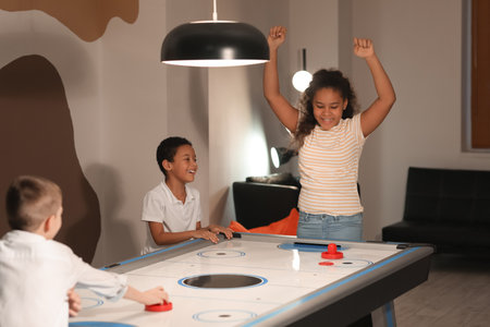 Little children playing air hockey indoorsの写真素材