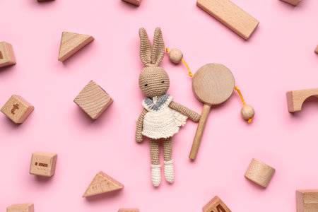 Wooden cubes with baby toys on pink backgroundの写真素材